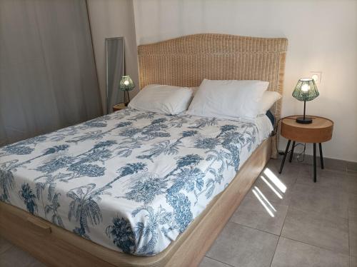 a bedroom with a bed with a blue and white blanket at "Air d'Antan"-Meublé de Tourisme 3 étoiles -Résidence "Les Logis de Béziers"-Garage optionnel-Cœur de ville-Plages à 16km ! in Béziers