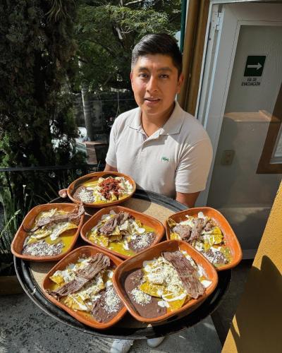a man sitting at a table with a tray of food at Hospedaje Casa Teotleco in Tepoztlán