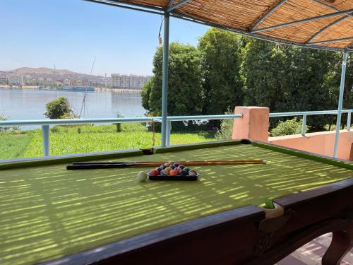 a green pool table with a bowl of balls on it at Nubian Holiday House Aswan in Aswan
