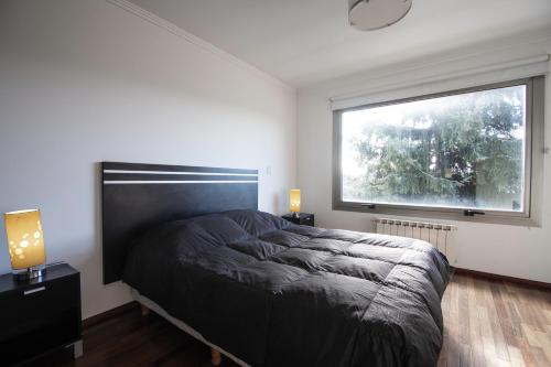 a bedroom with a bed and a large window at Great 2-Bedroom Apartment close Playa Bonita QL5 by Apartments Bariloche in San Carlos de Bariloche