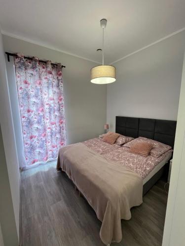 a bedroom with a bed and a large window at Apartamenty Na wzgórzu in Ińsko