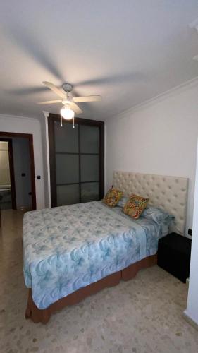 a bedroom with a bed with a ceiling fan at Piso bien ubicado y acogedor in Málaga