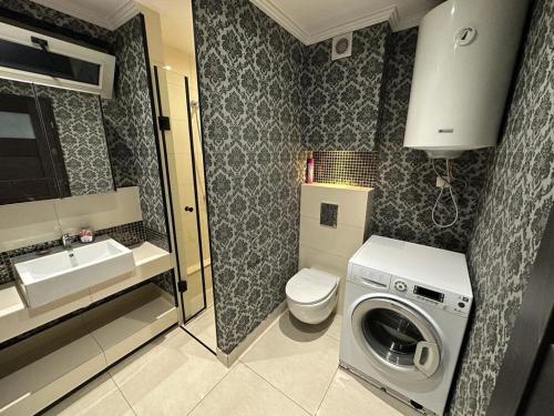a bathroom with a washing machine and a sink at Jaga House in Krakow free parking in Kraków