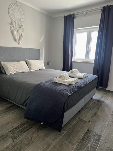 a bedroom with a bed with towels on it at Casa Pescador in Carvoeiro