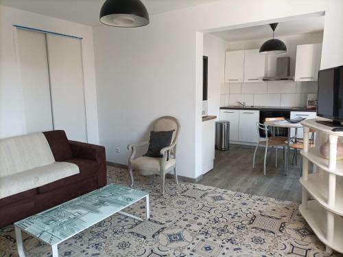 uma sala de estar com um sofá e uma mesa em "La Clé dès Champs"-Meublé de Tourisme 3 étoiles -Résidence "Les Logis de Béziers"-Garage optionnel-Cœur de ville-Plages à 16km ! em Béziers