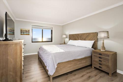 um quarto com uma cama grande e uma televisão em Oceanfront 2 Bedroom Modern Beach Condo w Pool em Ocean City