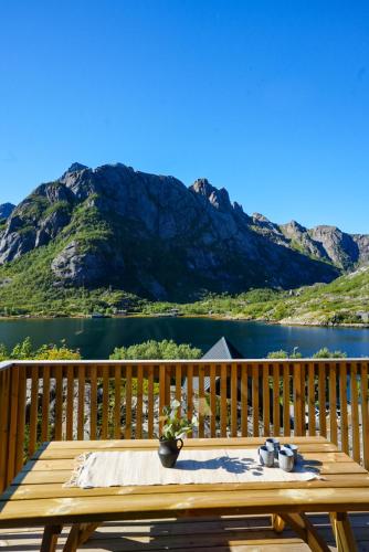a table on a deck with a view of a mountain at Lofoten Cabins in Hopen