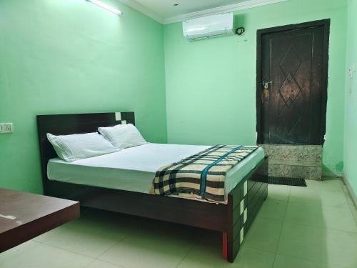 a bedroom with a bed in a room with green walls at ARUDRA BUDGET suites in Ongole
