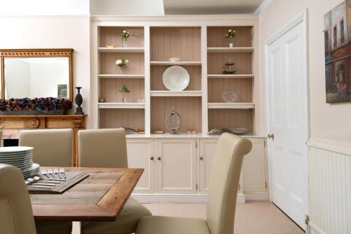 ein Esszimmer mit Tisch und Stühlen und einem Spiegel in der Unterkunft Downwood Vineyard Manor in Idyllic Countryside in Blandford Forum