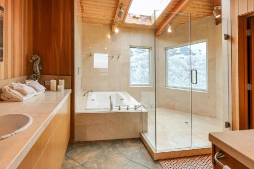 a bathroom with a tub and a glass shower at The Brass Seahorse in Gualala