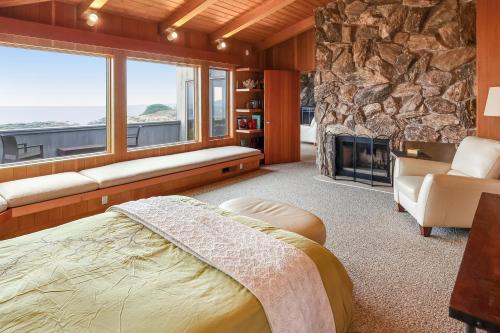 a bedroom with a fireplace and a stone wall at The Brass Seahorse in Gualala