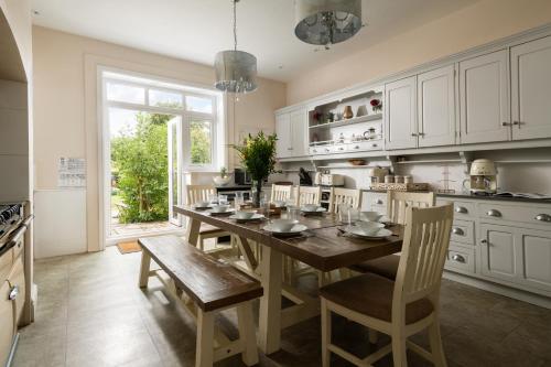 een keuken met een eettafel en stoelen bij Downwood Vineyard Manor in Idyllic Countryside in Blandford Forum