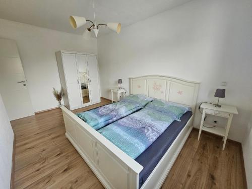 um quarto branco com uma cama grande e lençóis azuis em Wohnung in Gunskirchen / Wels em Gunskirchen