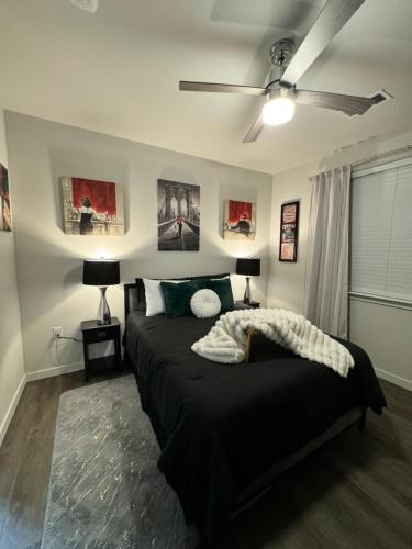 a bedroom with a black bed with a ceiling fan at Cozy Comfort Lux in Houston