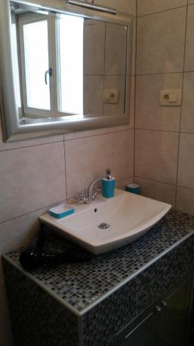 a bathroom sink with a mirror and a counter top at Apartments Rustic in Biograd na Moru