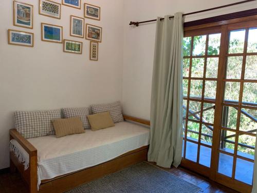 a couch in a room with a large window at Pousada da Mata in Cunha