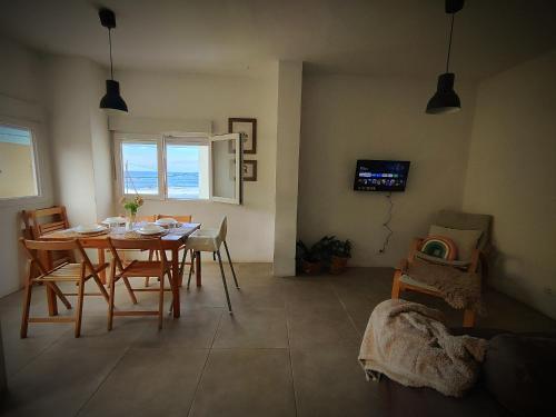 a dining room with a table and chairs and a television at Nueve Pies Surf casita in Las Palmas de Gran Canaria
