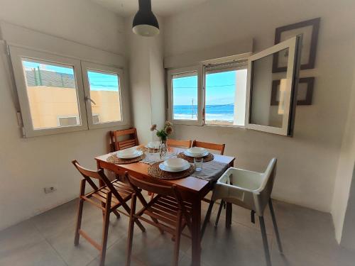 a dining room with a table and chairs and the ocean at Nueve Pies Surf casita in Las Palmas de Gran Canaria