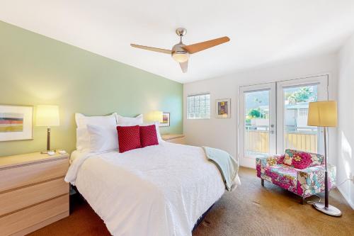 a bedroom with a white bed and a chair at Hermosa Hideaway Permit #39494 in Palm Springs