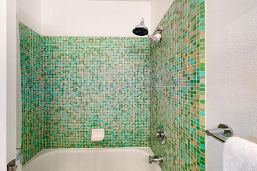 a bathroom with a green tiled shower with a tub at Hermosa Hideaway Permit #39494 in Palm Springs