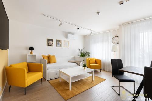 a living room with yellow chairs and a white couch at Pineapple Apartments Dresden Zwinger IX - 80 qm - 1x free parking - in Dresden