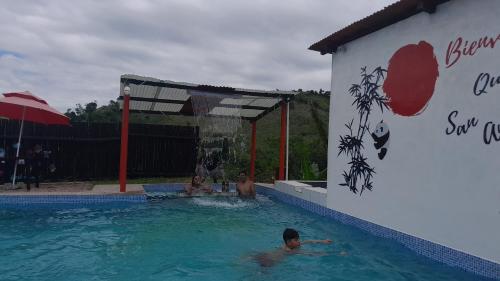 Hostería Quinta San Antonio في Nanegal: وجود مجموعة أشخاص في المسبح