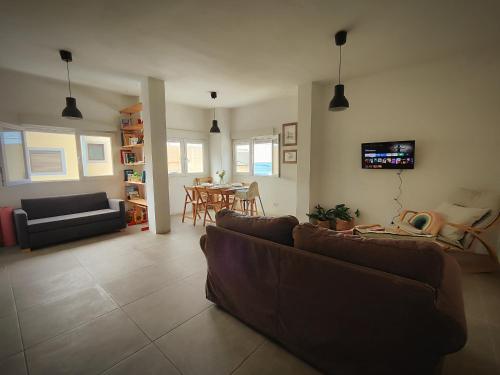 a living room with couches and a dining room at Nueve Pies Surf casita in Las Palmas de Gran Canaria