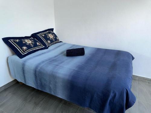 uma cama com um cobertor azul e almofadas em Peace Hut em Nadi