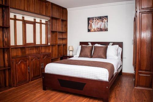 a bedroom with a large bed with wooden cabinets at Hermosa casa con lujoso rooftop en Cuenca in Cuenca