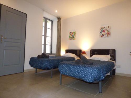a room with two beds with shoes on them at "Le Patio"-Meublé de Tourisme 3 étoiles -Résidence "Les Logis de Béziers"-Garage optionnel-Cœur de ville-Plages à 16km ! in Béziers