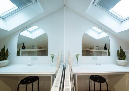 a bathroom with two sinks and two stools at Abbey Rd - St John's Wood Retreat by Aureva in London