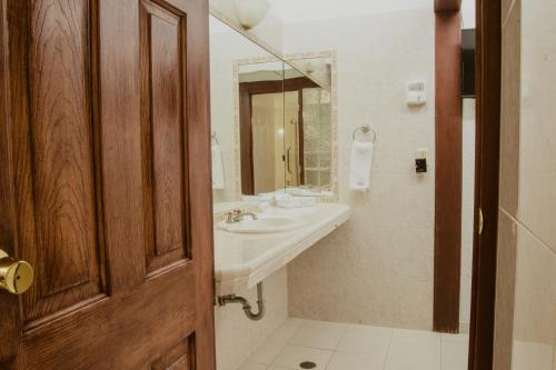 La salle de bains est pourvue d'un lavabo et d'un miroir. dans l'établissement Hotel Posada San Agustin, à Durango