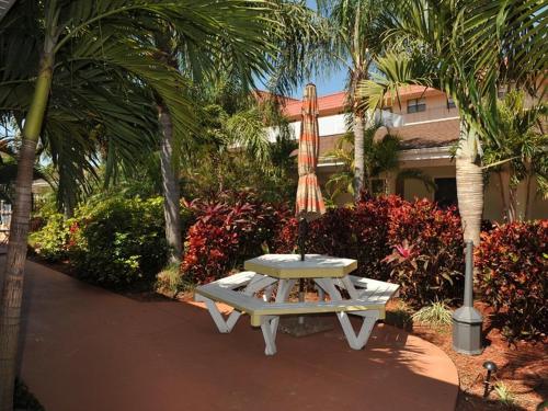 a picnic table in front of a building with palm trees at Hotel SOL in St Pete Beach