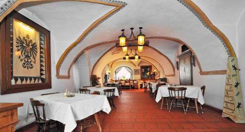 a restaurant with white tables and chairs and a chandelier at Gasthof Tell in Paternion