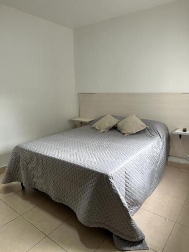 a bedroom with a bed with a white comforter at Monoambiente Céntrico2 in Santiago del Estero