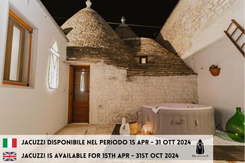 Habitación con un edificio de ladrillo y bañera de hidromasaje. en Milestones Modern Suite Trullo Jacuzzi Spa & Relax, en Alberobello