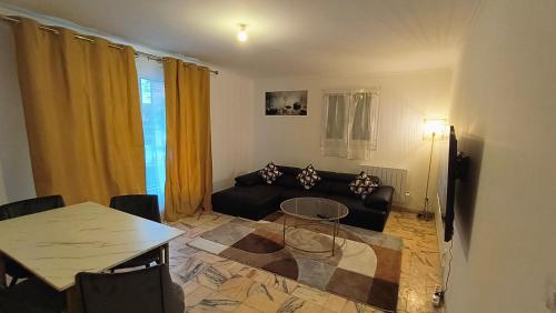 un salon avec un canapé noir et une table dans l'établissement Dujardin Home, à Montmagny