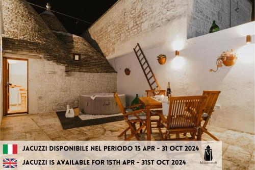 a room with a table and chairs and a bed at Milestones Modern Suite Trullo Jacuzzi Spa & Relax in Alberobello
