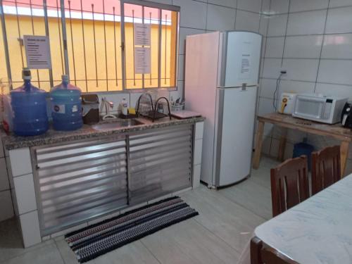 cocina con fregadero y nevera en Hostel My House quartos perto do aeroporto de Guarulhos en Guarulhos