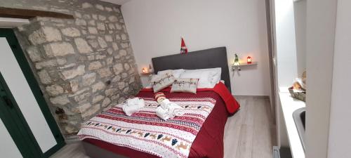 a bedroom with a red bed with a stone wall at Il Campanile in Santa Maria del Molise