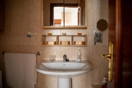 y baño con lavabo blanco y espejo. en Bonito piso en San Ildefonso - Centro, en Jaén