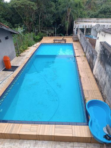 uma grande piscina azul num deque de madeira em Casa com piscina e Bilhar em Diadema