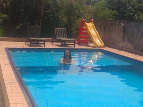 uma mulher numa piscina com escorrega em Casa com piscina e Bilhar em Diadema
