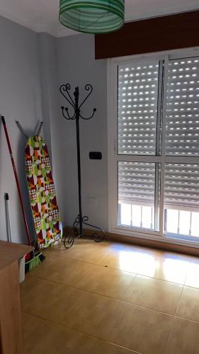 a living room with a large window with blinds at Piso bien ubicado y acogedor in Málaga