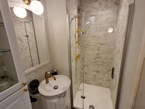 y baño blanco con lavabo y ducha. en Studio chaleureux & moderne, région bruxelloise, en Asse