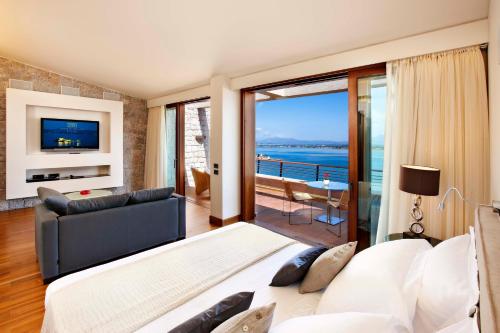 a living room with a view of the ocean at Nafplia Palace Hotel & Villas in Nafplio
