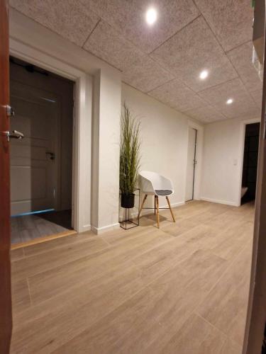 um quarto com um piano branco e um vaso de plantas em Enkeltværelse med fælles badeværelse em Esbjerg