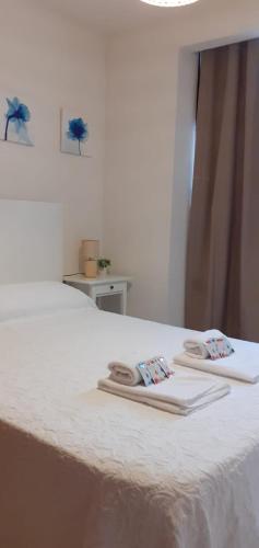 two towels are sitting on top of a bed at los pisitos de El Barraco 2 in El Barraco