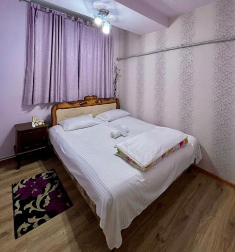 a bedroom with a bed with white sheets and a window at Apartment in the centre of Yerevan for rent in Yerevan
