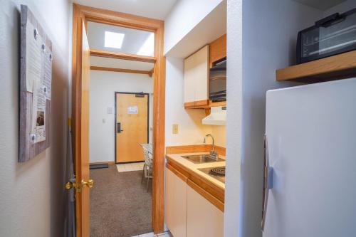 a small kitchen with a sink and a refrigerator at Cozy Brian Head Condo Walk to Navajo Express Lift in Brian Head